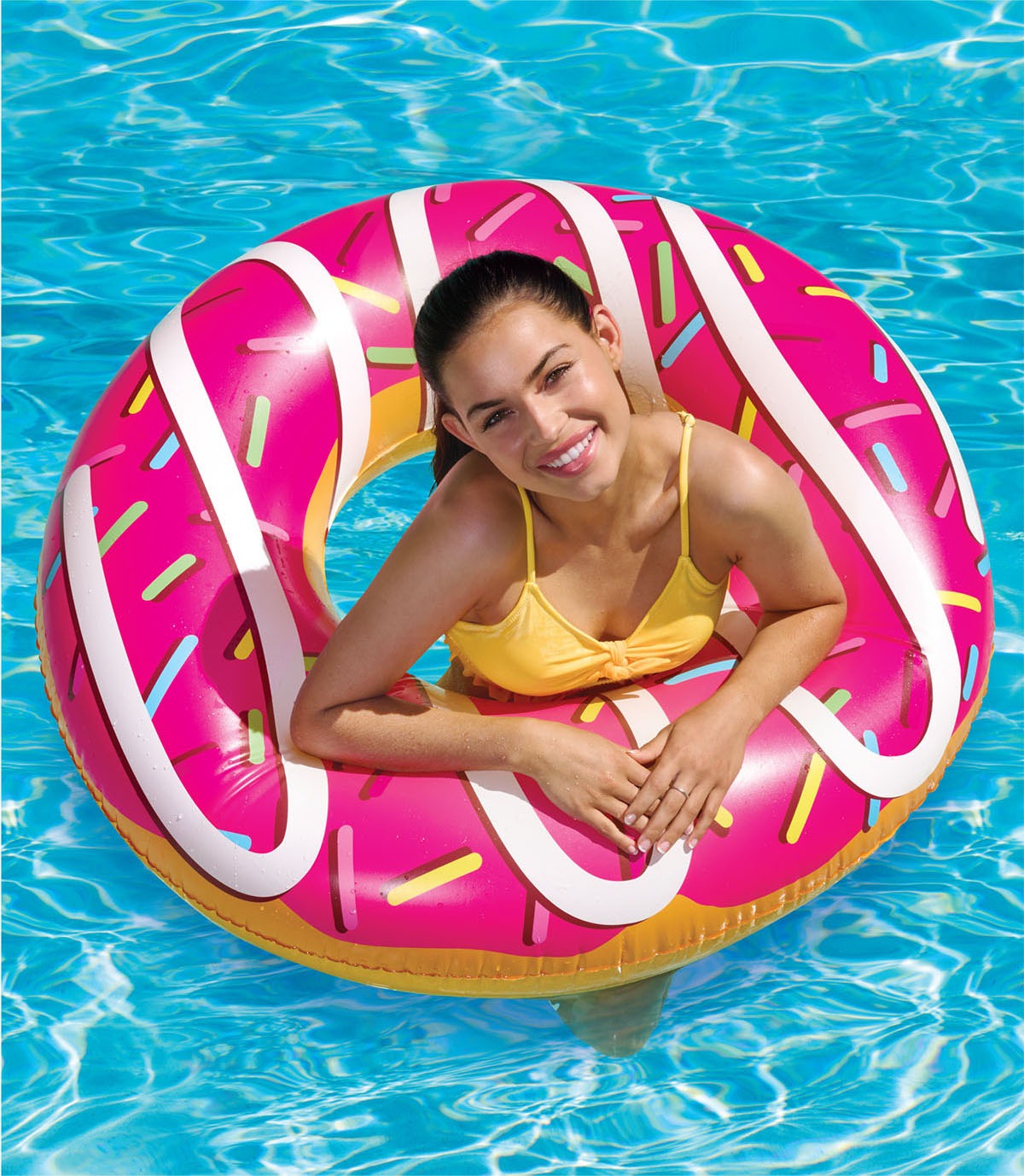 Lifestyle product photography: young girl using pink donut inflatable pool float